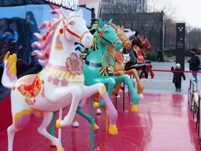 A child looks at horse figures decorated outside a shopping mall ahead of the 2026 Lunar New Year of the Horse, in Beijing, China, Wednesday, Jan. 28, 2026. (AP Photo/Vincent Thian)