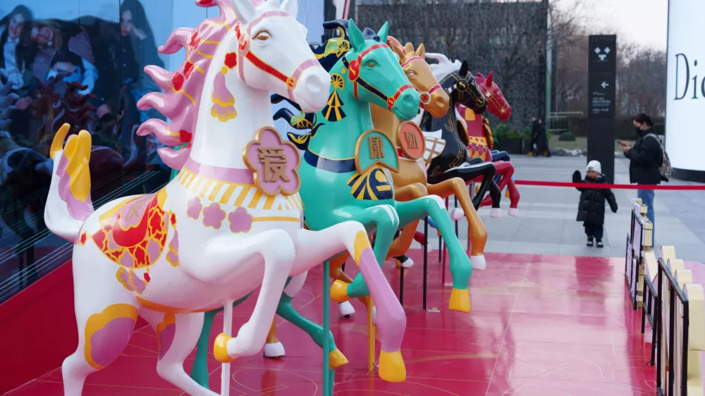 A child looks at horse figures decorated outside a shopping mall ahead of the 2026 Lunar New Year of the Horse, in Beijing, China, Wednesday, Jan. 28, 2026. (AP Photo/Vincent Thian)