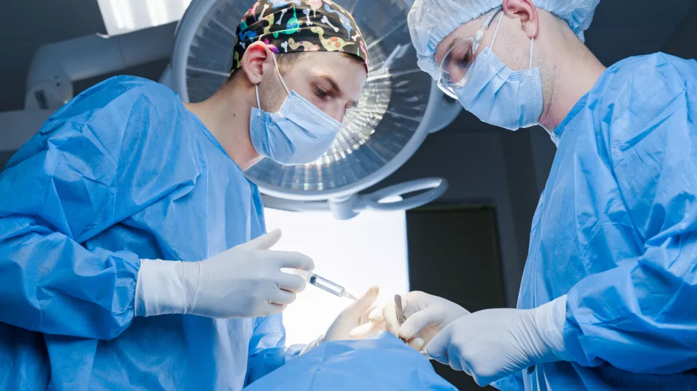 Anesthesia thigh injection before Buccal fat removal. Bisha lumps removal. Plastic surgery in clinic. Surgery operation for modifying the eye region of the face in medical clinic.