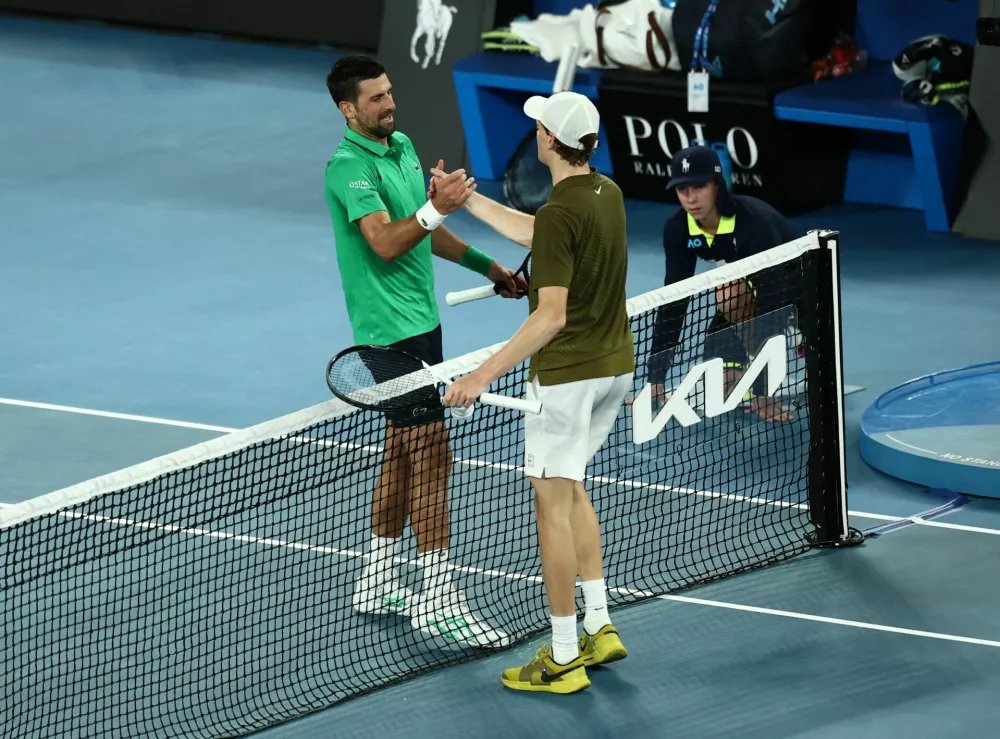 Tennis - Australian Open - Melbourne Park, Melbourne, Australia - January 31, 2026 Serbia's Novak Djokovic shakes hands with Italy's Jannik Sinner after winning his semi final match REUTERS/Tingshu Wang