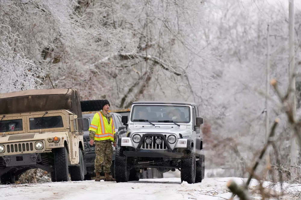 Tennessee National Guard member talks to a motorist along an ice covered road Friday, Jan. 30, 2026, in Nashville, Tenn. (AP Photo/George Walker IV)