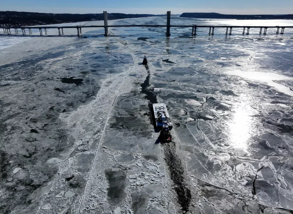 A drone view of a tug boat breaking a path through the ice for a tanker barge heading south on the Hudson River towards the Governor Mario M. Cuomo Bridge as Arctic cold temperatures continue across much of the northeastern U.S. near Tarrytown, New York, U.S., January 30, 2026. REUTERS/Mike Segar