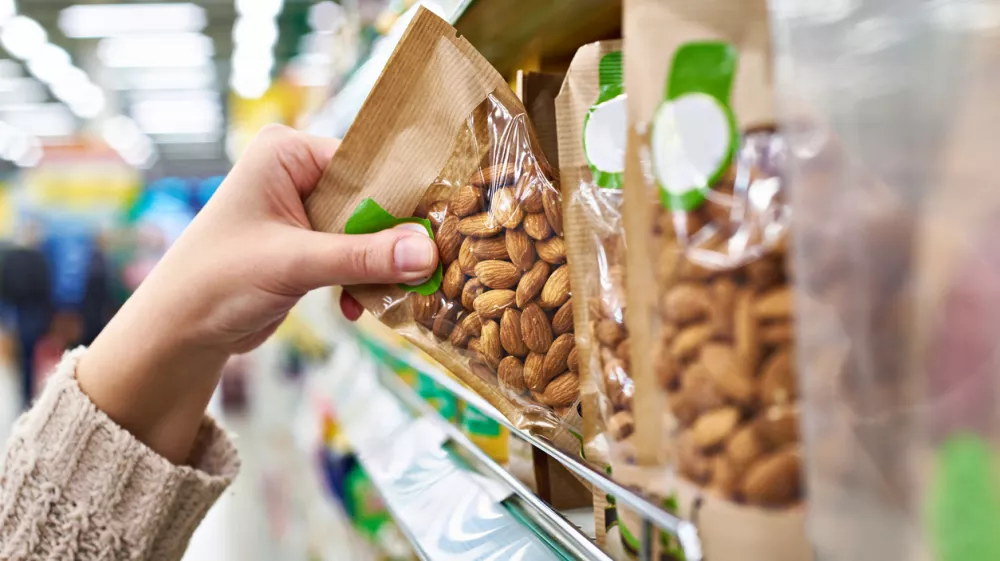 Hand of the buyer with the packaging of almond nuts in the store / Foto: Sergeyryzhov, Getty Images/istockphoto