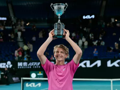 Ziga Sesko of Slovenia holds his trophy aloft after defeating Keaton Hance of the U.S. in the boy's singles final at the Australian Open tennis championship in Melbourne, Australia, Sunday, Feb. 1, 2026. (AP Photo/Dar Yasin)