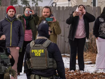 Observers film while federal agents conduct immigration enforcement operations, on Thursday, Feb. 5, 2026, in Minneapolis. (AP Photo/Ryan Murphy)