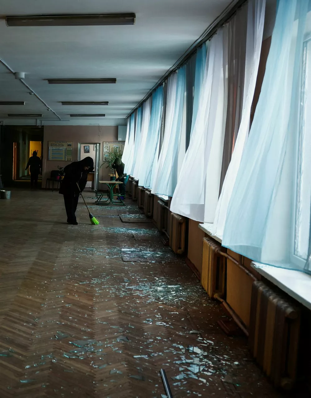 Teachers clean up debris inside a school building damaged in a Russian drone strike on a nearby apartment, amid Russia's attack on Ukraine, in Kyiv, Ukraine February 3, 2026. REUTERS/Valentyn Ogirenko