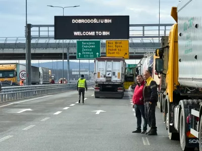Men stand next to a line of trucks and buses on the Bosnian side of the border with Croatia, in Svilaj, Bosnia, Monday, Jan. 26, 2026, as drivers across the Balkans blocked dozens of border crossings in the region in protest over newly introduced European Union entry regulations.(AP Photo/Eldar Emric) / Foto: Eldar Emric