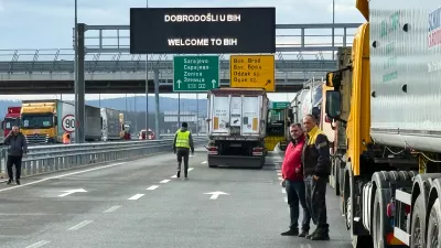 Men stand next to a line of trucks and buses on the Bosnian side of the border with Croatia, in Svilaj, Bosnia, Monday, Jan. 26, 2026, as drivers across the Balkans blocked dozens of border crossings in the region in protest over newly introduced European Union entry regulations.(AP Photo/Eldar Emric) / Foto: Eldar Emric