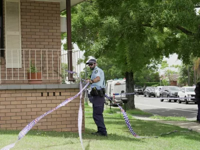A police officer removes police tape from outside the house of the suspects of a shooting incident on a Jewish holiday celebration at Bondi Beach, in Bonnyrigg, Sydney, Australia, December 15, 2025. REUTERS/Alasdair Pal