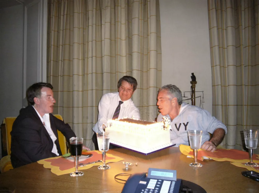 Peter Mandelson sits with late financier and convicted sex offender Jeffrey Epstein, as he blows out the candles on a cake, in an undated photograph released by the Department of Justice in Washington, D.C., U.S., on December 19, 2025 as part of a trove of documents from its investigations into Epstein. U.S. Justice Department/Handout via REUTERS  THIS IMAGE HAS BEEN SUPPLIED BY A THIRD PARTY.