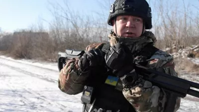 Ukrainian national police officer, holding a shotgun used as a counter-drone weapon, holds a drone fibre-optic cable, during an evacuation of residents from the Tavriiske and Yurkivka villages in Ukraine's Zaporizhzhia region, amid Russia's attack on Ukraine, in this screengrab from a video, February 3, 2026. Reuters TV via REUTERS THIS IMAGE HAS BEEN SUPPLIED BY A THIRD PARTY