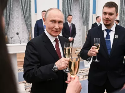 Russian President Vladimir Putin, center, toasts with participants of a ceremony to present the 2025 Presidential Prizes in Science and Innovation for Young Scientists at the Kremlin, in Moscow, Thursday, Feb. 5, 2026. (Kristina Solovyova/Sputnik, Kremlin Pool Photo via AP)