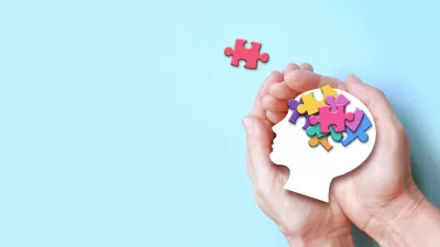 Hands holding paper head with jigsaw puzzle, Autism spectrum disorder family support concept, World Autism Awareness Day. / Foto: Belitas