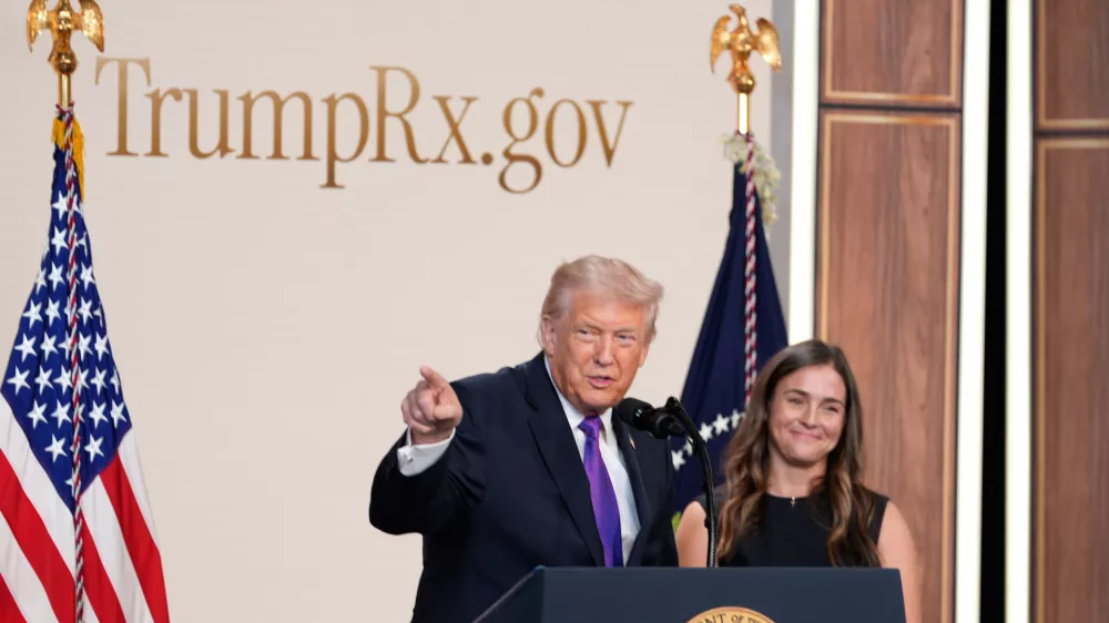 President Donald Trump speaks about TrumpRx in the South Court Auditorium in the Old Eisenhower Executive Office Building on the White House campus, Thursday, Feb. 5, 2026, in Washington, as Catherine Rayner listens. (AP Photo/Alex Brandon)