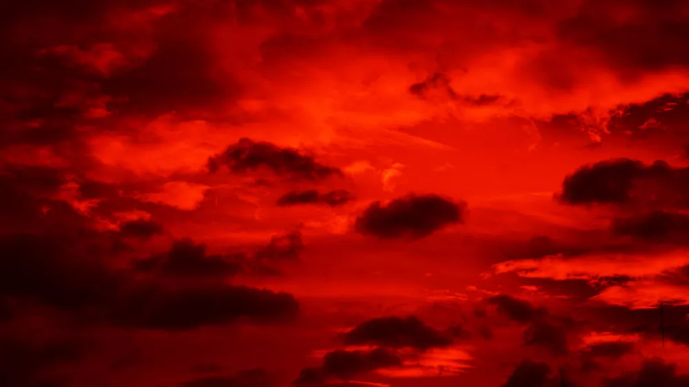 Bright red sunset. Dramatic evening sky with clouds. Fiery skies with space for design. Magic fantasy sky. War, battle, terror, world apocalypse, horror concept. / Foto: Natalya Bosyak