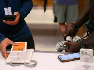 FILE PHOTO: A man purchases an iPhone 17 series with cash at the Apple Store in New York City, U.S., September 19, 2025. REUTERS/Shannon Stapleton/File Photo