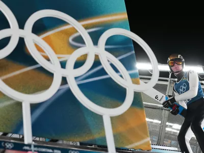 Domen Prevc, of Slovenia, carries his skis to the ramp for a jump during a ski jumping, men's normal hill, training session, at the 2026 Winter Olympics, in Predazzo, Italy, Sunday, Feb. 8, 2026. (AP Photo/Matthias Schrader)