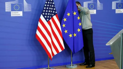 FILE PHOTO: A worker adjusts European Union and U.S. flags at the EU Commission headquarters in Brussels, November 11, 2013./File Photo