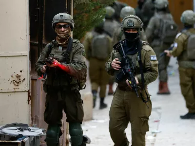 Israeli soldier points his weapon towards the camera, during a weekly settlers' tour in Hebron, in the Israeli-occupied West Bank, February 7, 2026. REUTERS/Mussa Qawasma