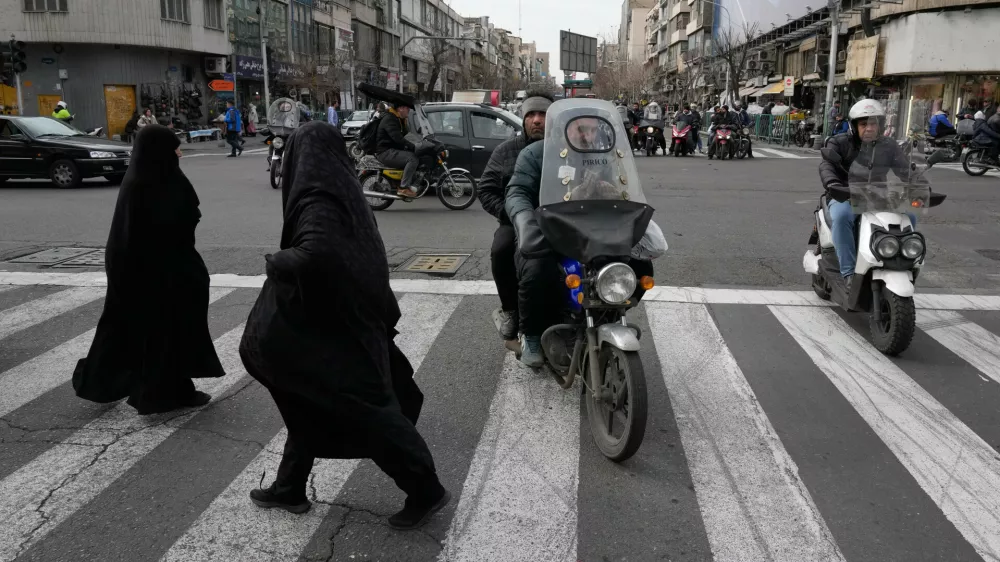 Women cross an intersection in downtown Tehran, Iran, Monday, Feb. 9, 2026. (AP Photo/Vahid Salemi)