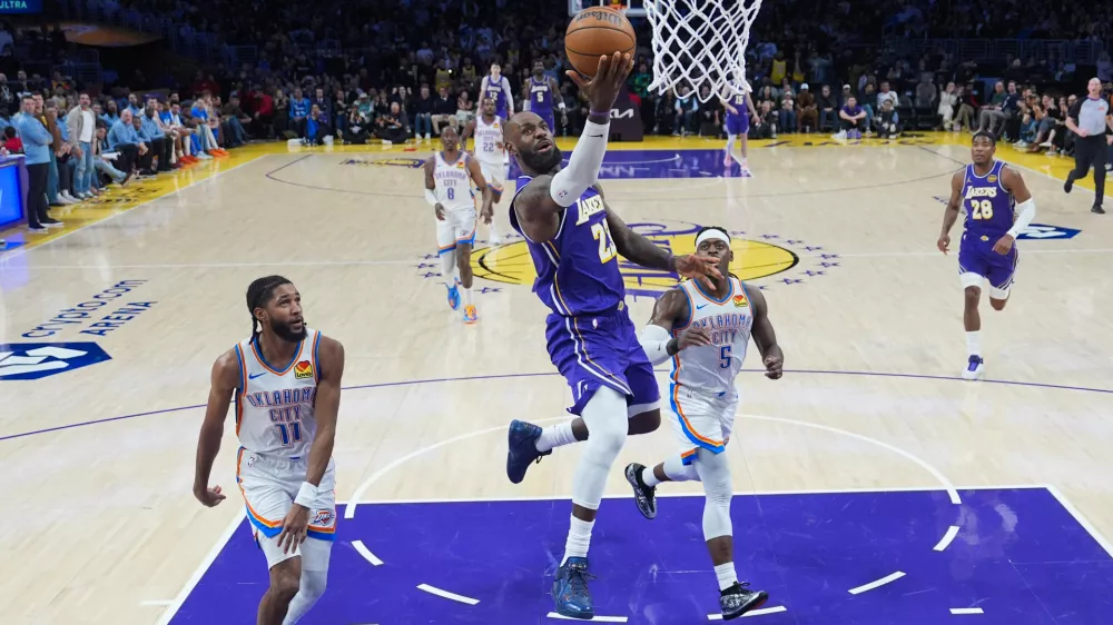 Los Angeles Lakers forward LeBron James (23) puts up a shot as Oklahoma City Thunder guard Isaiah Joe (11) and guard Luguentz Dort (5) watch during the second half of an NBA basketball game Monday, Feb. 9, 2026, in Los Angeles. (AP Photo/Jae C. Hong)
