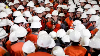 French President Emmanuel Macron, wearing a working helmet, gestures as he delivers a speech surrounded by employees as he visits the Mardyck Electryck site dedicated to the electric steel production at one of steelmaker ArcelorMittal's plants in Dunkirk, northern France, February 10, 2026. REUTERS/Benoit Tessier/Pool  TPX IMAGES OF THE DAY