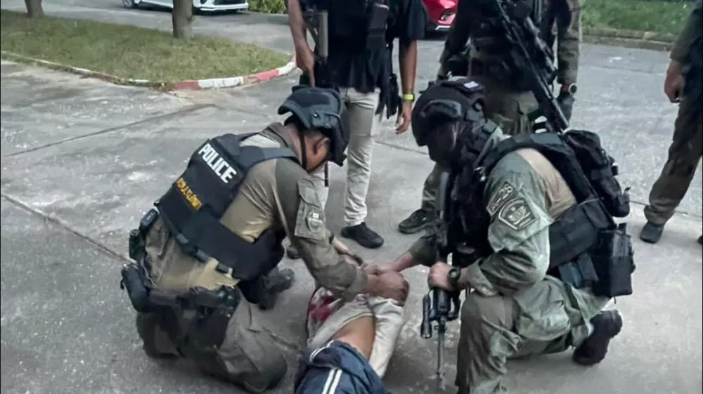 This photo released by the Royal Thai Police, shows Thai police arresting a man at Patongprathankiriwat School in Hat Yai, Songkhla province, Thailand, Wednesday, Feb. 11, 2026. (Royal Thai Police via AP)