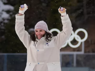 Julia Simon, of France, celebrates gold during a medals ceremony for the women's 15-kilometer individual biathlon race at the 2026 Winter Olympics in Anterselva, Italy, Wednesday, Feb. 11, 2026. (AP Photo/Andrew Medichini)