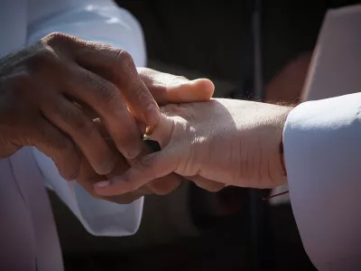 A person places a wedding ring on their partner's finger as they marry during the "Love in Times Square" event on Valentine's Day, Saturday, Feb. 14, 2026, in New York. (AP Photo/Andres Kudacki)