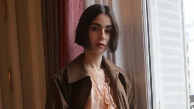 Minulo nedeljo je Lily Collins, ki v seriji Netflix Emily v Parizu igra glavno junakinjo, prispela v Pariz z vlakom Venice Simplon-Orient-Express in bila ujeta v objektivih med promocijo prihajajoče sezone. Nosila je drzen, blush toniran kos spodnjega perila, ki ga je Saint Laurent oblikoval Anthony Vaccarello, oblečenega skupaj s čokoladno rjavim trench pla&scaron;čem in usnjenim clutch torbico. Outfit velja za enega najbolj drznih, ki jih je Collins nosila doslej, &scaron;e posebej za igralko, katere osebni slog se običajno nagiba k klasični eleganci. Nova sezona Emily v Parizu bo na Netflixu na voljo 22. decembra 2025, kar bo priložnost, da gledalci ponovno vidijo Emily v drzni modni izbiri.
