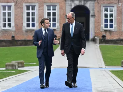 HANDOUT - 12 February 2026, Belgium, Bilzen: German Chancellor Friedrich Merz and French President Emmanuel Macron arrive to the EU leader's informal meeting in Bilzen. Photo: FREDERIC SIERAKOWSKI/European Council/dpa - ATTENTION: editorial use only and only if the credit mentioned above is referenced in full