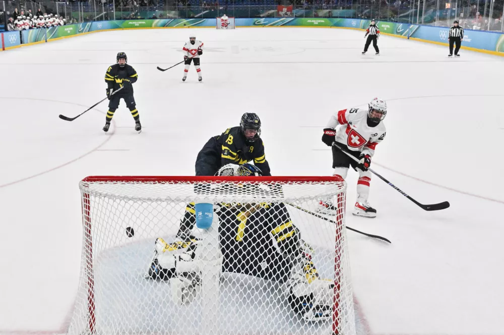Switzerland's Alina Muller, right, scores the winning goal, during a women's ice hockey bronze medal game between Switzerland and Sweden at the 2026 Winter Olympics, in Milan, Italy, Thursday, Feb. 19, 2026. (Alexander Nemenov/Pool Photo via AP)
