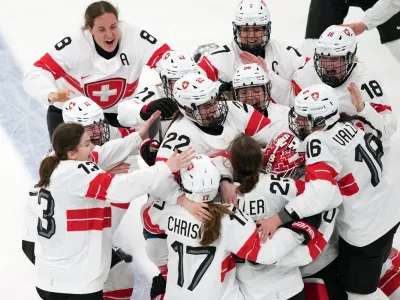 Team Switzerland players celebrate after Alina Muller (25) scored the winning goal in overtime to beat Sweden in the women's ice hockey bronze medal game at the 2026 Winter Olympics, in Milan, Italy, Thursday, Feb. 19, 2026. (AP Photo/Carolyn Kaster)