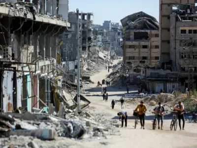 FILE PHOTO: Palestinians make their way in a devasted neighborhood, amid the ongoing Israel-Hamas conflict, in Gaza City, October 24, 2024. REUTERS/Dawoud Abu Alkas/File Photo