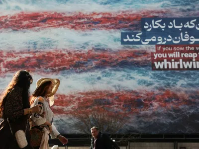 Iranian women walk past an anti-U.S. billboard in Tehran, Iran, February 19, 2026. Majid Asgaripour/WANA (West Asia News Agency) via REUTERS ATTENTION EDITORS - THIS PICTURE WAS PROVIDED BY A THIRD PARTY