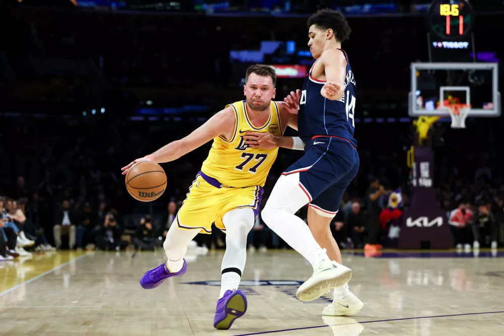 Los Angeles Lakers guard Luka Doncic (77) drives against Los Angeles Clippers center Yanic Konan Niederhauser during the first half of an NBA basketball game, Friday, Feb. 20, 2026, in Los Angeles. (AP Photo/Jessie Alcheh)
