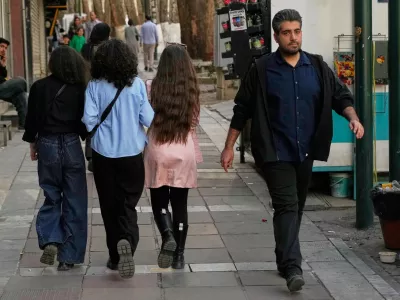 People walk on a sidewalk in northern Tehran, Iran, Friday, Feb. 20, 2026. (AP Photo/Vahid Salemi)