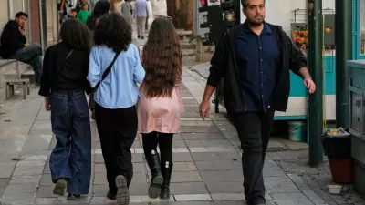 People walk on a sidewalk in northern Tehran, Iran, Friday, Feb. 20, 2026. (AP Photo/Vahid Salemi)