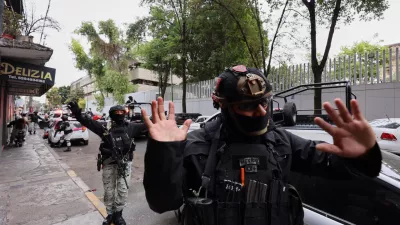 National Guards remove pedestrians by the General Prosecutor's headquarters in Mexico City, Sunday, Feb. 22, 2026, after the death of the leader of the Jalisco New Generation Cartel, Nemesio Rubén Oseguera Cervantes, known as "El Mencho." (AP Photo/Ginette Riquelme)