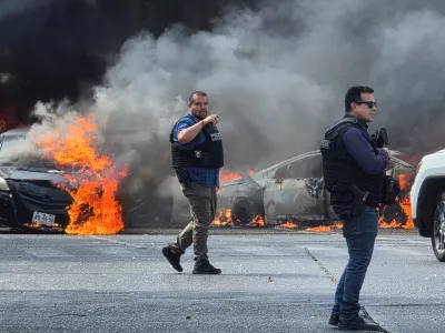 Police officers secure the area where vehicles were set on fire by organized crime members to block a road following a military operation in which a government source said Mexican drug lord Nemesio Oseguera, commonly known as "El Mencho," was killed, in Zapopan, Mexico, February 22, 2026. REUTERS/Gilberto Gallo   TPX IMAGES OF THE DAY
