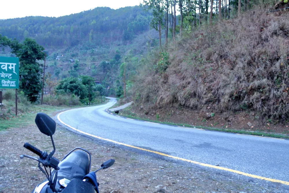 road in the middle of the hill forest, bus is on the road.