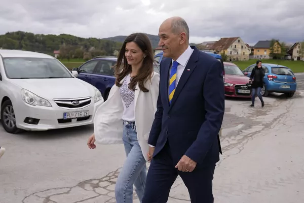 Slovenia's Prime Minister Janez Jansa with his wife Urska Bacovnik Jansa walks away from a polling station in Sentilj, Slovenia, Sunday, April 24, 2022. Slovenians cast ballots in a parliamentary election that is expected to be a tight race between Prime Minister Janez Jansa's ruling right-wing populists and liberals in the politically divided European Union nation. (AP Photo/Darko Bandic)