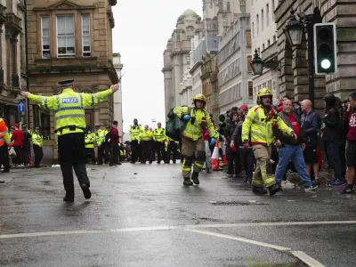 Police and emergency personnel deal with an incident on Water Street near the Liver Building in Liverpool after a car collided with pedestrians during the Premier League winners parade, in Liverpool, England, Monday May 26, 2025. (Owen Humphreys/PA via AP)