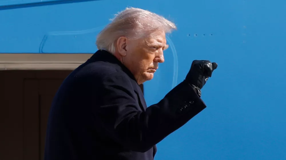 President Donald Trump gestures from the stairs of Air Force One upon his arrival at Joint Base Andrews, Md., Friday, Feb. 27, 2025. (AP Photo/Luis M. Alvarez)