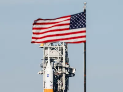 NASA's next-generation moon rocket, the Space Launch System (SLS) rocket with the Orion crew capsule, rolls from its launch pad back to the Vehicle Assembly Building for repairs ahead of the Artemis II mission launch at the Kennedy Space Center in Cape Canaveral, Florida, U.S., February 25, 2026. The capsule is behind the press site flag. Launch is scheduled no earlier than April 1, 2026. REUTERS/Joe Skipper