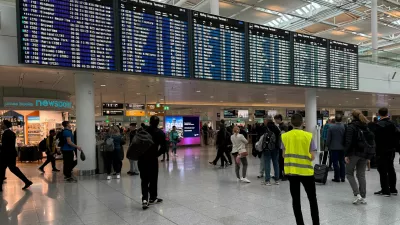 People walk past the departure board at the airport in Munich, after it was gradually resuming flights with delays expected through the day, hours after both runways were closed for the second time in less than 24 hours due to a drone sighting, in Munich, Germany, October 4, 2025. REUTERS/Ayhan Uyanik