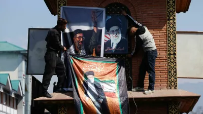 Shi'ite Muslims tie banners of Iran's Supreme Leader Ayatollah Ali Khamenei to a clock tower during a protest march, chanting anti-U.S. and anti-Israel slogans after he was killed in Israeli and U.S. strikes on Saturday, in Srinagar, Indian Kashmir, March 1, 2026. REUTERS/Sharafat Ali