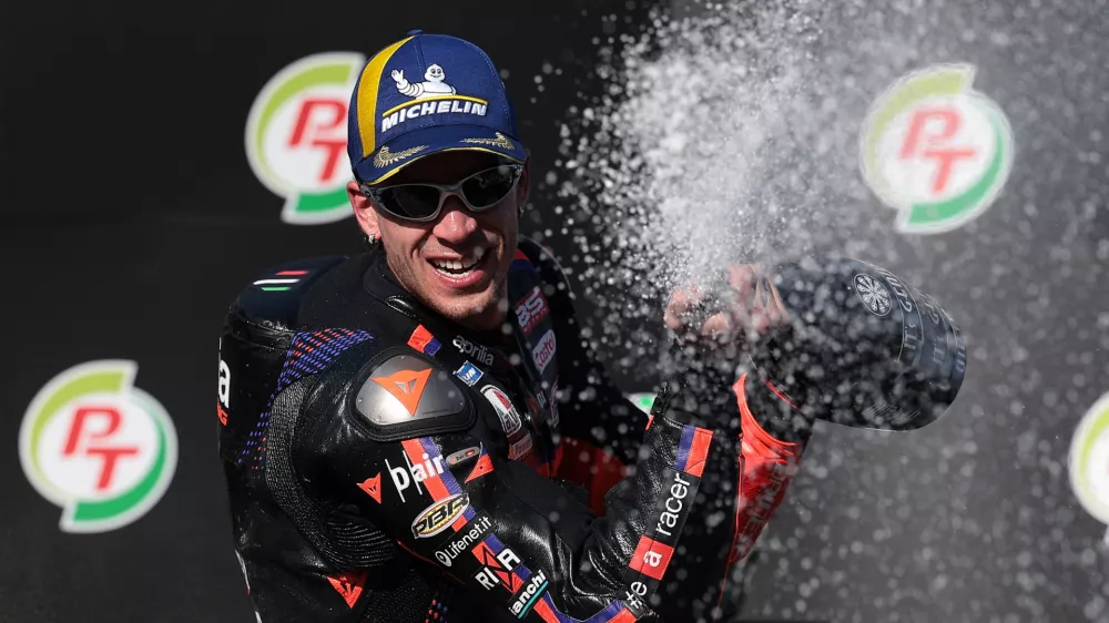 MotoGP - Thailand Grand Prix - Chang International Circuit, Buriram, Thailand - March 1, 2026 Aprilia Racing's Marco Bezzecchi celebrates winning the MotoGP race on the podium with the trophy REUTERS/Chalinee Thirasupa
