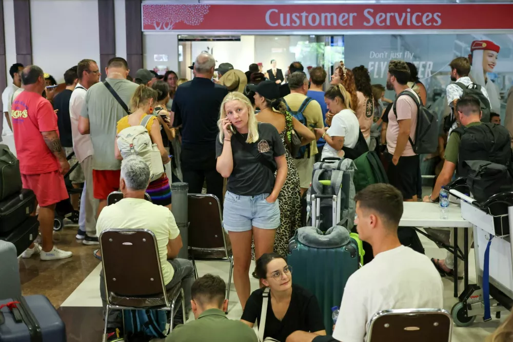 Stranded passengers wait near Emirates Airways customer service office at I Gusti Ngurah Rai International Airport after flights to Doha, Dubai, and Abu Dhabi were cancelled following strikes on Iran launched by the United States and Israel, in Kuta, Bali, Indonesia, March 1, 2026. REUTERS/Johannes Christo