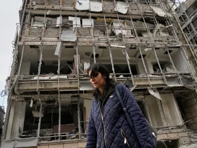 A woman walks by the damaged Gandhi Hospital, which was hit when a strike struck a state TV communications tower and nearby buildings across the street during the ongoing joint U.S.-Israeli military campaign in Tehran, Iran, Monday, March 2, 2026. (AP Photo/Vahid Salemi)